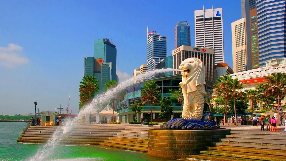 Merlion statue spouting water in front of the Singapore skyline